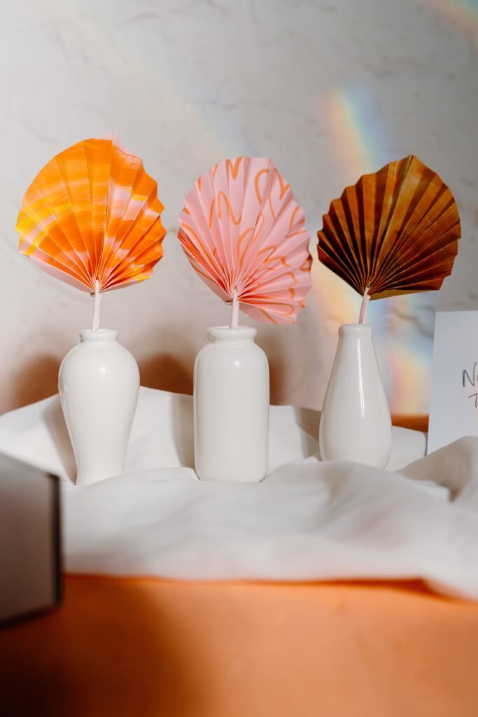 three ceramic vases with handmade coloured fans